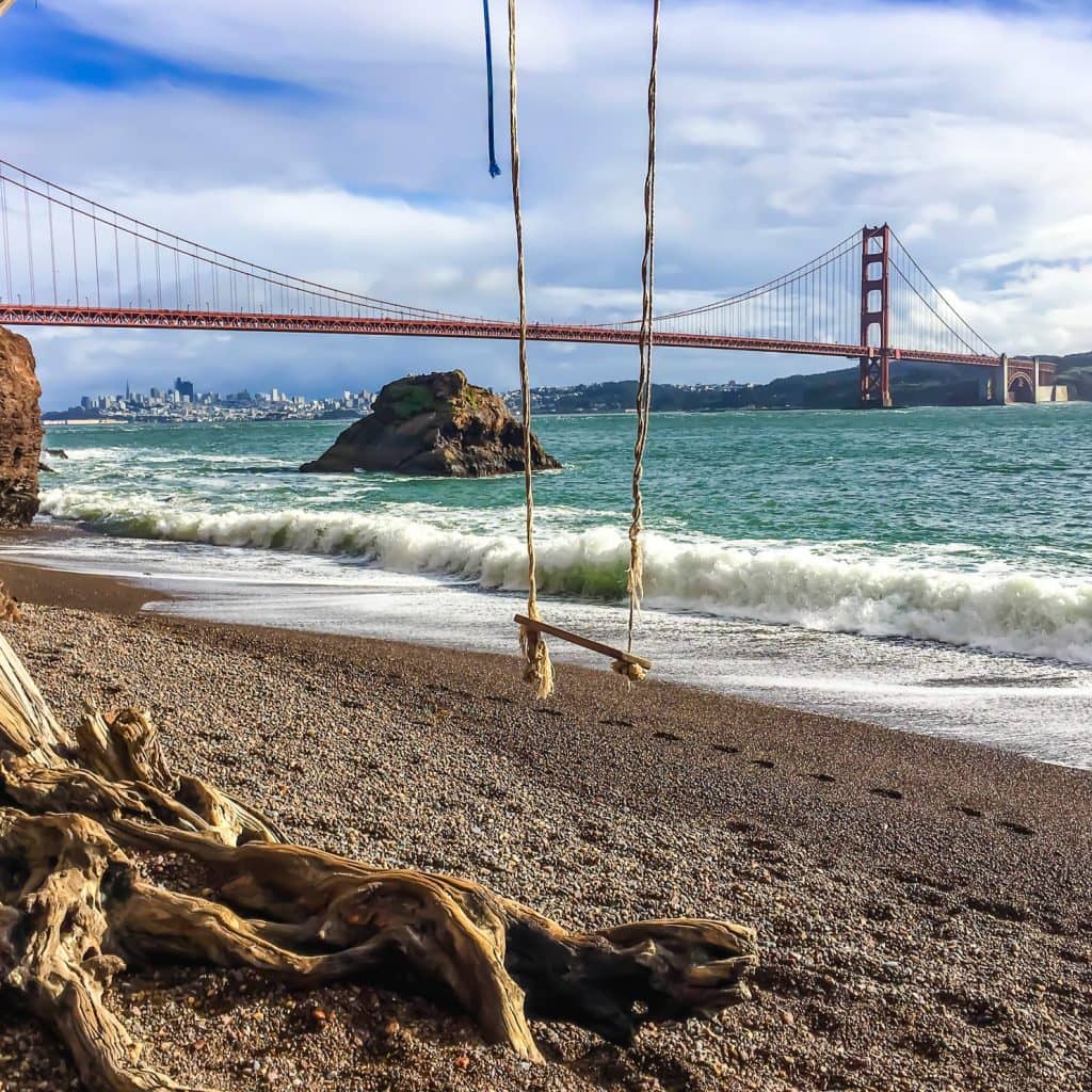 Kirby Cove Swing overlooking the Golden Gate Bridge and the Pacific Ocean on a sunny day.